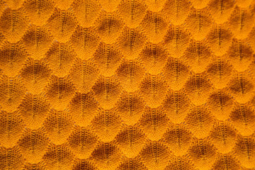 Orange knitted background. Close up gray fabric texture background. wrinkled and shadows, selective focus top view