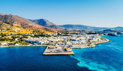 Small costal village aerial view from above. Fascinating landscape of village by the sea with mountains on the background, Paros, Greece