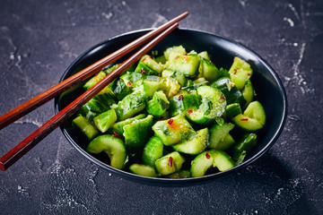 Smashed Cucumber salad in a black bowl
