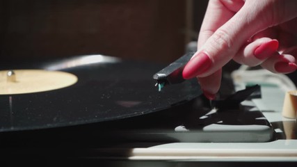 Video of woman with red nails turning on retro gramophone