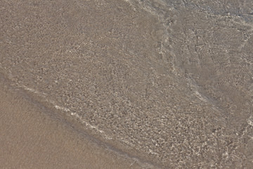 Fototapeta na wymiar Sea water and sand, top view.