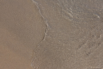 Sea water and sand, top view.