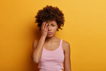 Dejected offended woman going to cry, covers half of face, looks unhappily at camera, feels...