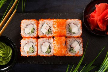 Set of sushi rolls with wasabi and ginger on a black background. Japanese oriental cuisine