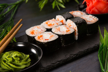 Set of sushi rolls with wasabi and ginger on a black background. Japanese oriental cuisine