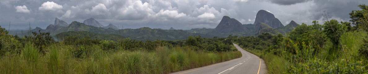 Panorama view of a road on the tropical landscape, with forest and mountains Kumbira forest reserve in Angola - obrazy, fototapety, plakaty