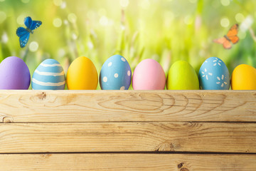 Easter holiday bacjground with easter eggs over green grass meadow
