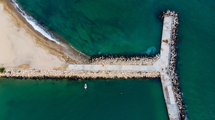 Concrete tetrapod wave breaker with a boat anchored by the side