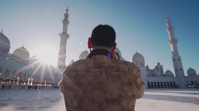 Young Caucasian Man Taking Picture of Sheikh Zayed Grand Mosque as He Visits Abu Dhabi in UAE. Foreign Tourist with Professional Photo Camera Exploring Arab Countries in Middle East