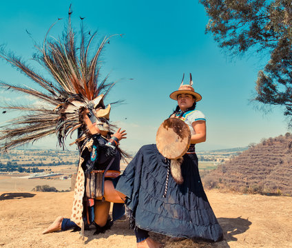 Mexican dancers posing at camera with tufts and pre-Hispanic dress