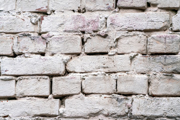 Weathered and old rustic brick wall closeup painted white. Texture, space for text and wallpaper concept.