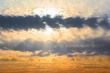 Fototapeta premium Beautiful sunset sky. Sun through dark thick fluffy clouds natural sunset sky view background.