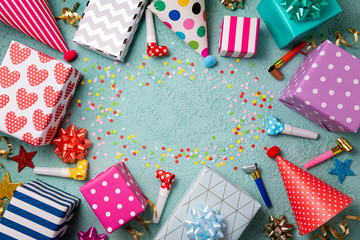 Fototapeta premium Happy birthday background. Party accessories confetti, gift boxes, party hats, wistle. Happy birthday celebrate concept. Top view, flat lay, copy space