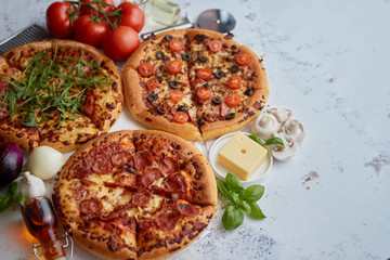 Three american style pizzas served on a table