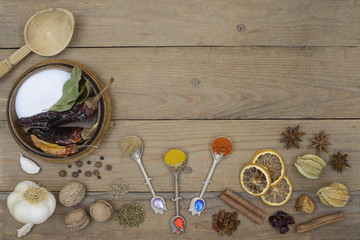 Dried spices, garlic and walnuts on old wooden planks in rustic style. Copy space.