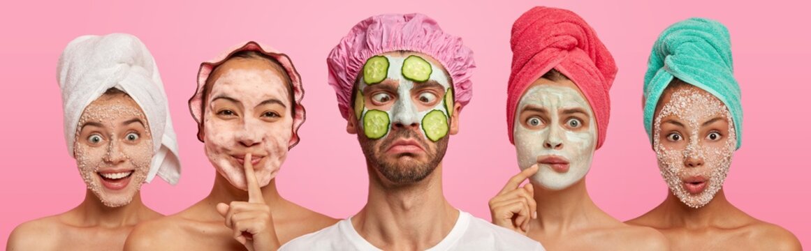 Funny Crazy Man Crosses Eyes, Applies Slices Of Cucumbers And Clay Mask, Wears Bath Hat, Stands Between Four Women With Towels On Heads, Applied Scrubs Or Clay Masks, Pose All Together Indoor