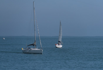 Two sailboats on the blue sea