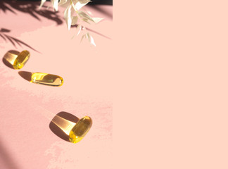 Liquid gelatin capsules with flower shadow on pink background