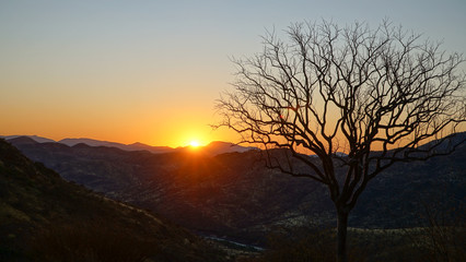 Sunset and orange sky near Epupa Falls waterfall in the Kaokoland of Namibia, Africa.
