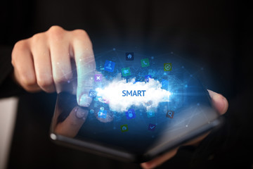 Businessman holding a foldable smartphone with SMART inscription, technology concept