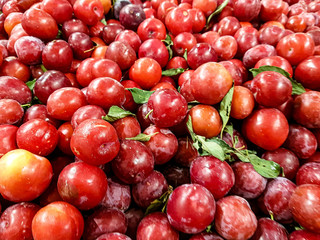 A lot of cherries are on the counter of the fruit store.