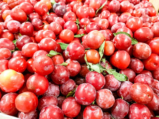 A lot of cherries are on the counter of the fruit store.