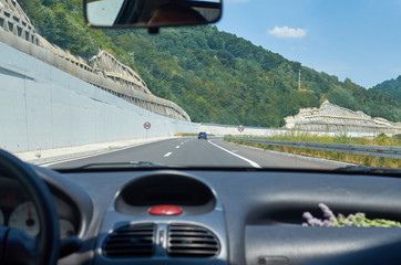 Modern highway through a picturesque gorge, seen from a vehicle in motion