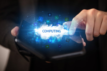 Businessman holding a foldable smartphone with COMPUTING inscription, technology concept