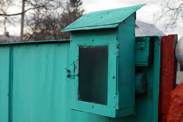 old green mailbox on the fence near the gate