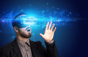 Businessman looking through Virtual Reality glasses with RELIABLE PROTECTION inscription, cyber security concept
