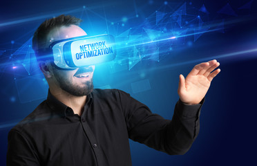 Businessman looking through Virtual Reality glasses with NETWORK OPTIMIZATION inscription, cyber security concept