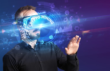 Fototapeta na wymiar Businessman looking through Virtual Reality glasses with CRYPTO MINING inscription, innovative technology concept