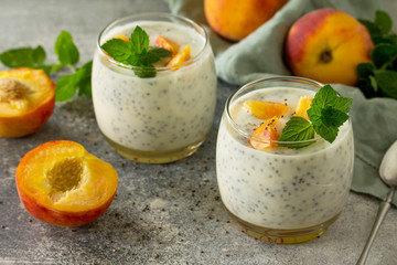 Natural detox, fruit dessert, healthy dieting concept. Peach Yogurt smoothie or milk shake with chia seeds in glass jar on a stone concrete worktop.