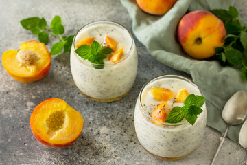 Natural detox, fruit dessert, healthy dieting concept. Peach Yogurt smoothie or milk shake with chia seeds in glass jar on a stone concrete worktop.