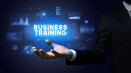 Hand of Businessman holding BUSINESS TRAINING inscription, business success concept