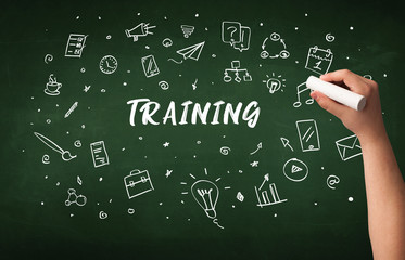 Hand drawing TRAINING inscription with white chalk on blackboard, education concept