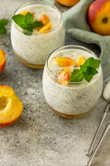 Natural detox, fruit dessert, healthy dieting concept. Peach Yogurt smoothie or milk shake with chia seeds in glass jar on a stone concrete worktop. Copy space.