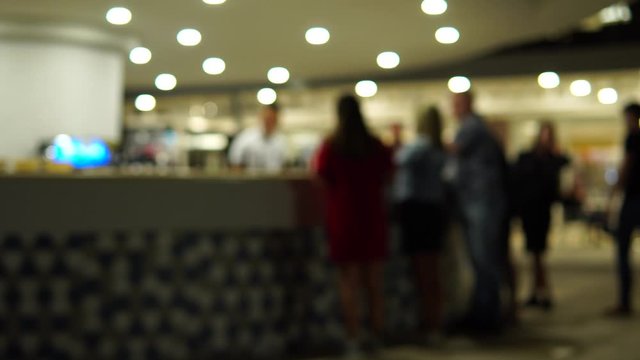 Blurred bar counter. Night party. The queue of people near the bar.