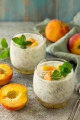 Natural detox, fruit dessert, healthy dieting concept. Peach Yogurt smoothie or milk shake with chia seeds in glass jar on a stone concrete worktop.