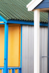 Fototapeta na wymiar Abstract view of Beach huts. Sutton on Sea beach hut juxtaposition of colours and structure of huts. Various colours in vivid shades and brightness. Summertime holiday resort.