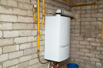 Wall-mounted gas boiler with a pipe to the street, mounted on the wall.