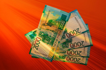 Russian money on an orange background. 2 thousand rubles written in Russian. Currency of Russia and the DPR. A ray of light in the dark realm.