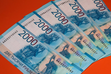 Obraz premium Russian money on an orange background. 2 thousand rubles written in Russian. Currency of Russia and the DPR.
