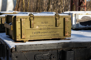 Ammunition box  in green camouflage paint of the Soviet Army on a railway platform. Text in Russian...