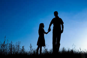 happy parent with child in the park outdoors silhouette