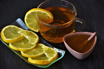 tea with lemon in a glass goblet and honey in a small bowl