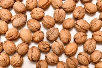 The background, closeup detailed, of walnuts laid out in the form of many colors on a white background.