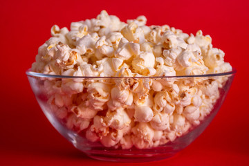 Delicious popcorn in a bowl on a red background
