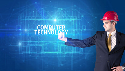 Handsome architect with helmet drawing COMPUTER TECHNOLOGY inscription, new technology concept
