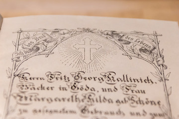 Kreuz einer geöffneten antiken Lutherbibel zeigt die evangelische Kirche und Übersetzung von Martin Luther mit einer verzierten Ausgabe der Bibel von 1914